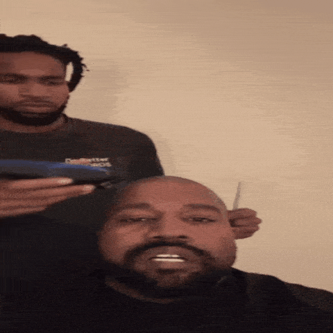 a man with a beard is getting his head shaved