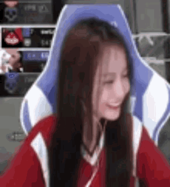 a woman is sitting in a blue and white gaming chair .