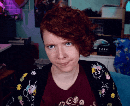 a woman with red hair is wearing a shirt that says buttons on it