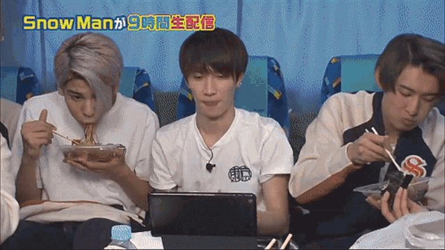 a group of young men are eating noodles in front of a laptop with the words snow man written above them