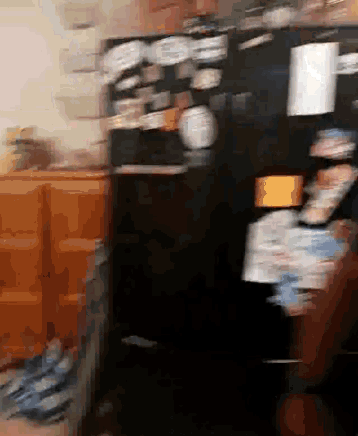 a blurry picture of a kitchen with a black refrigerator and a bunch of dishes