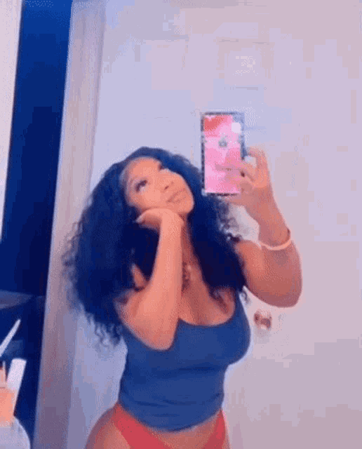 a woman is taking a selfie in a mirror .