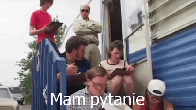 a group of men are sitting on the stairs of a trailer .