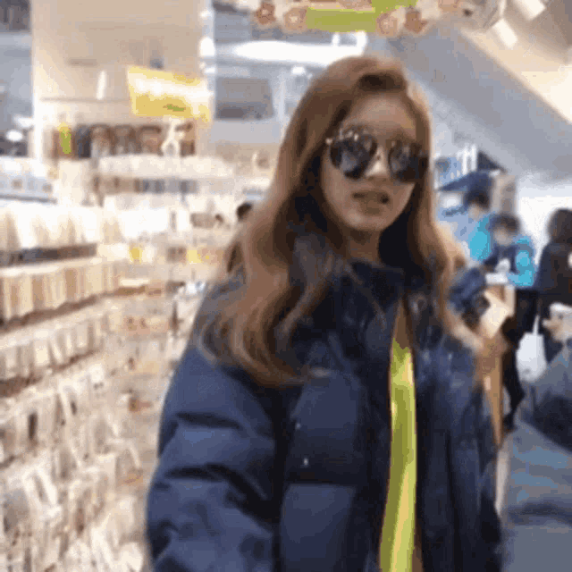 a woman wearing sunglasses is standing in a store .