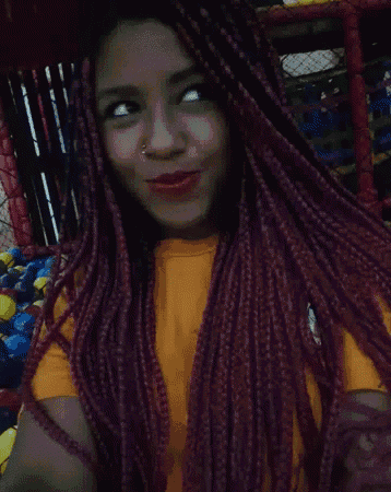 a girl with purple braids is wearing a yellow shirt and red lipstick