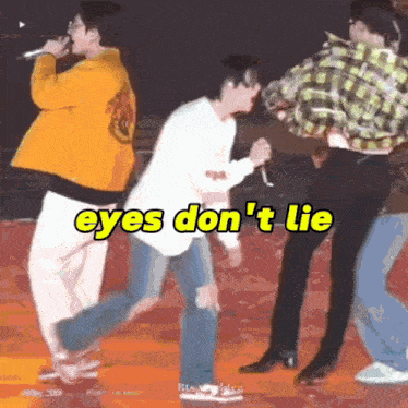 a group of people are standing on a stage with the words eyes don 't lie written on the bottom .