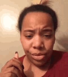 a woman with a nose ring is making a funny face while holding a lipstick .