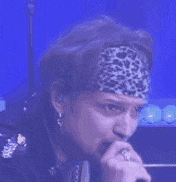 a man wearing a headband and gloves is making a face .