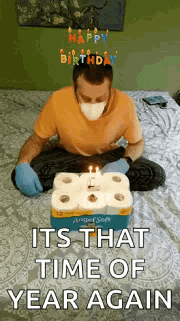 a man wearing a mask and gloves is celebrating his birthday with a box of angel soft toilet paper