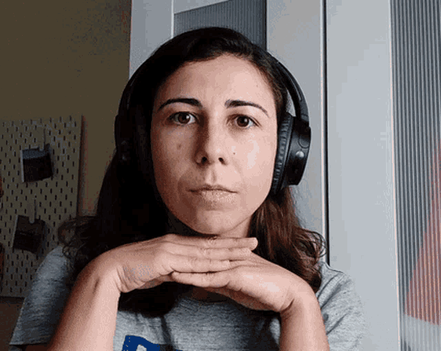 a woman wearing headphones and a gray shirt with the letter p on it