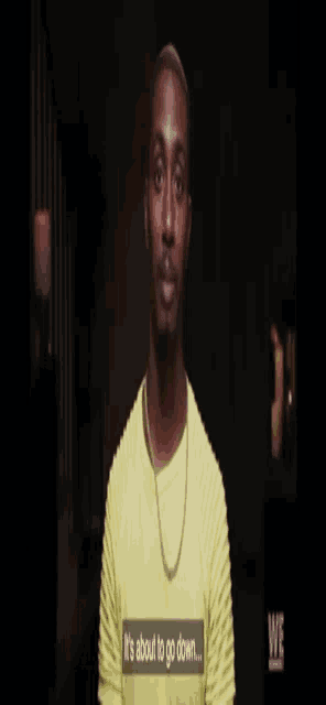 a man in a yellow shirt says it 's about to go down on a screen