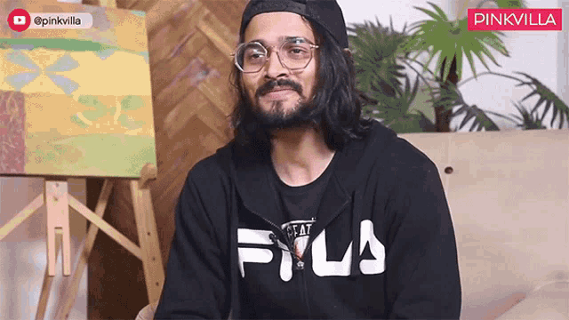 a man wearing glasses and a black fila sweatshirt