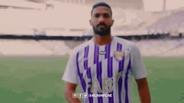 a man wearing a purple and white striped shirt that says fab on it