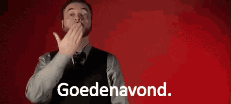 a man in a vest and tie is covering his mouth with his hand and the word goedeavond is written on the bottom