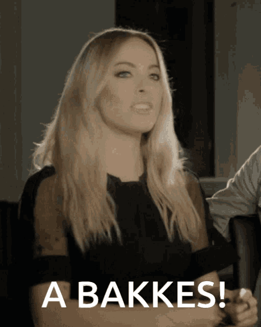 a woman says " a bakkes " in front of a black background