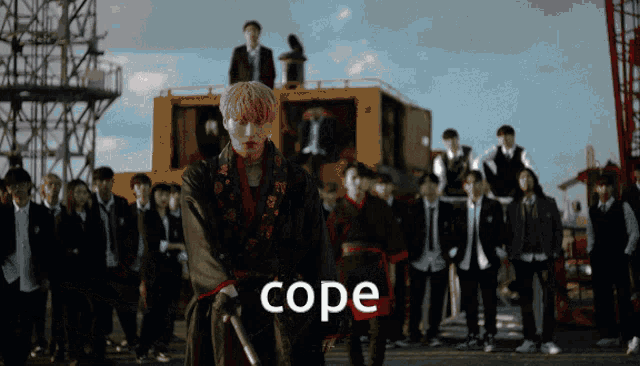 a group of people are standing in front of a yellow crane and the word cope is on the bottom right