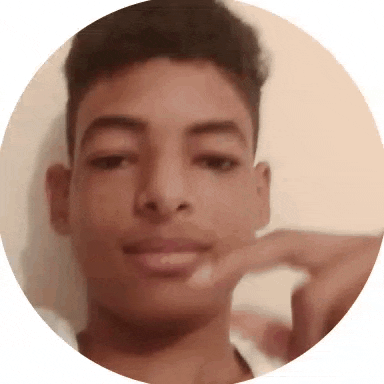 a close up of a young man 's face in a circle with his hand on his chin .