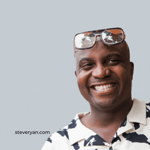 a man wearing glasses is smiling in front of a gm gm logo