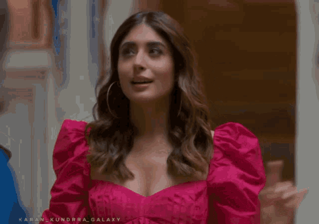 a woman in a pink dress with the name karan kundra galaxy on the bottom