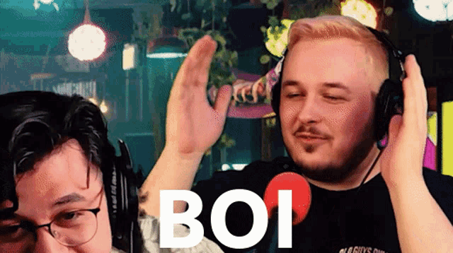 two men wearing headphones with the word boi in white