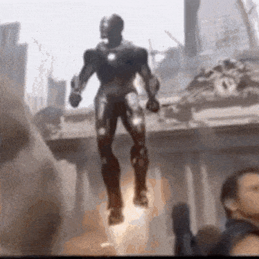 a statue of iron man is flying through the air in a city .
