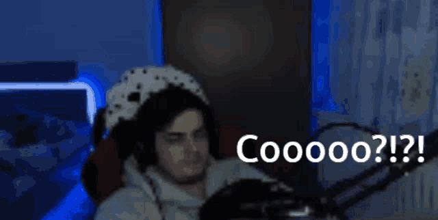 a man wearing a dalmatian hat is sitting in front of a microphone and says coooo ? ! ?