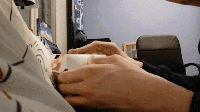 a close up of a person 's hands holding a piece of paper