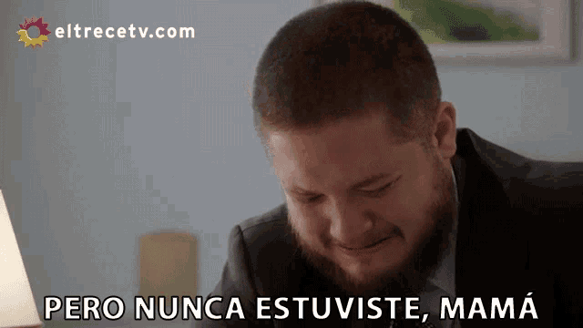 a man with a beard is sitting in front of a screen that says eltrecetv.com