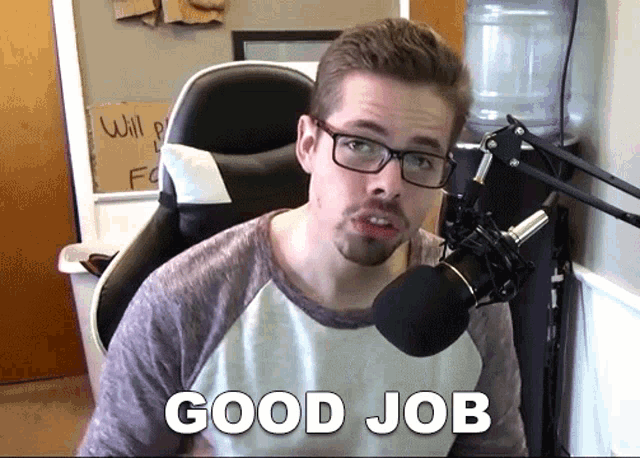 a man sitting in front of a microphone with the words good job on the bottom