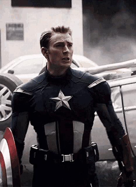 a man in a captain america uniform is standing in front of a car