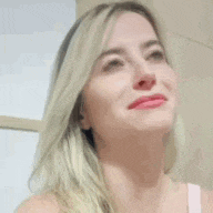 a close up of a woman 's face with blonde hair and red lips .