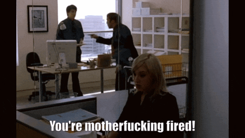 a woman is sitting at a desk with the words you 're motherfucking fired