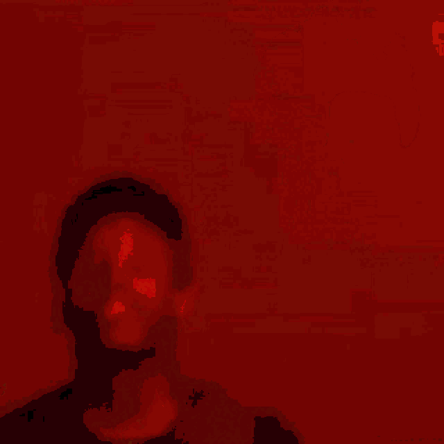 a blurry picture of a man in a black shirt standing in a dark room .