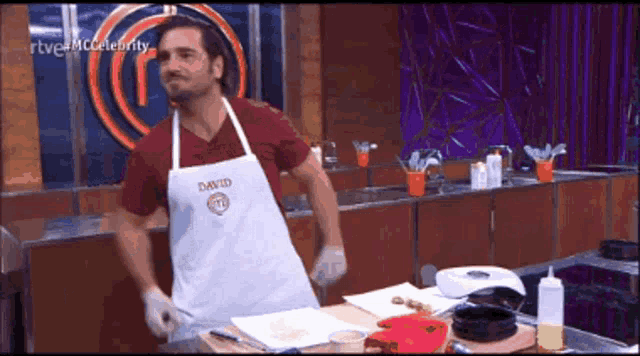 a man wearing an apron that says david is standing in a kitchen