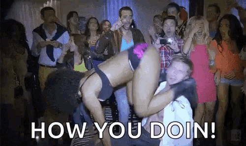 a man is carrying a woman on his shoulders at a party with the words `` how you doin '' .