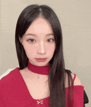 a woman wearing a red sweater and a choker necklace