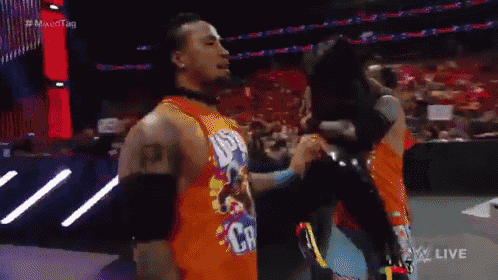 a wrestler wearing an orange shirt that says us