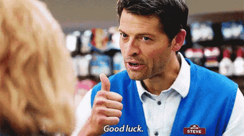 a man in a blue vest is giving a woman a thumbs up .
