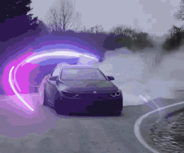 a car is driving down a road with a purple light behind it