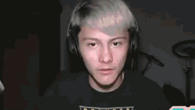 a man wearing headphones is making a funny face while looking at the camera .
