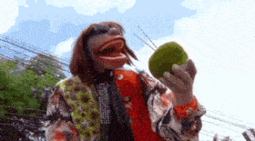 a clown is holding a coconut in his hand .