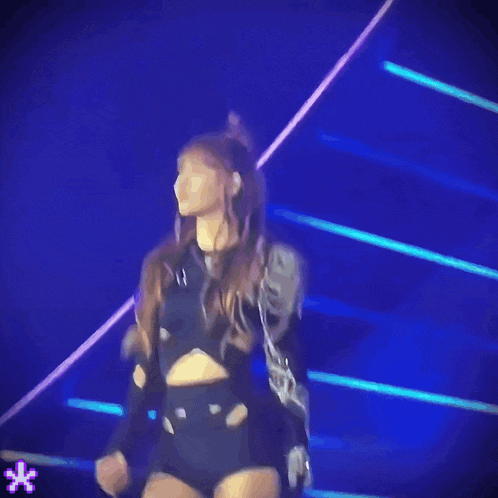a woman in a black crop top is dancing on stage