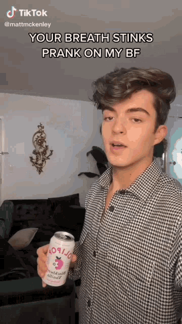 a young man is holding a can of rootbeer and making a funny face