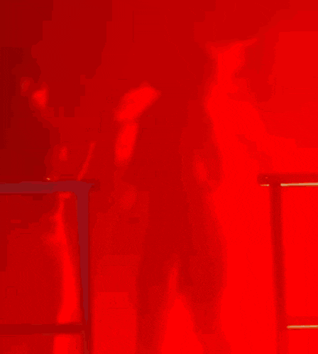 a woman in a red dress is touching another woman 's neck