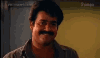 a man with a mustache is smiling with his eyes closed and his mouth open .