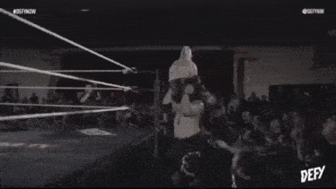 a black and white photo of a wrestling match with the words defy on the bottom
