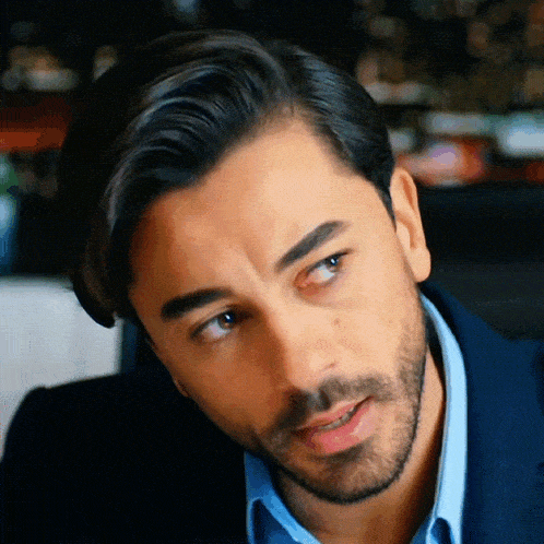 a man with a beard is wearing a blue jacket