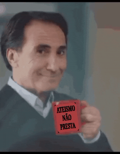 a man holds up a red card that says ateismo nao presta
