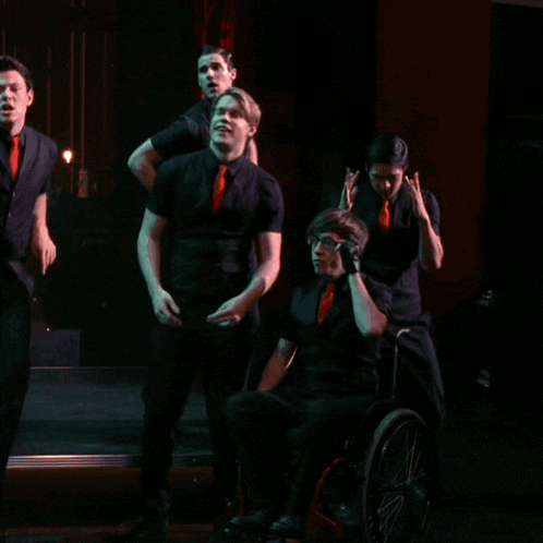 a man in a black shirt and red tie is dancing