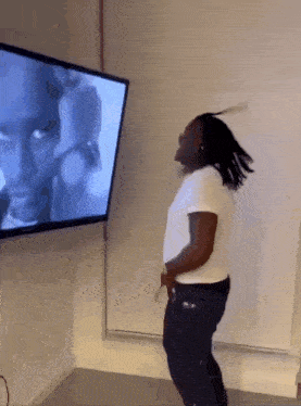 a man is dancing in front of a television screen